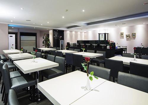 高雄美王精品飯店的一间设有白色桌椅的用餐室