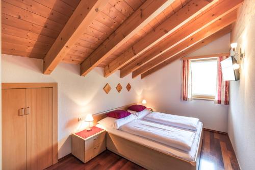 施勒肯Haus Rothorn的一间带一张床的卧室,位于带木制天花板的房间内