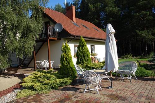 新托梅希尔贝纳索夫斯卡农家乐的一个带桌子和白色遮阳伞的庭院