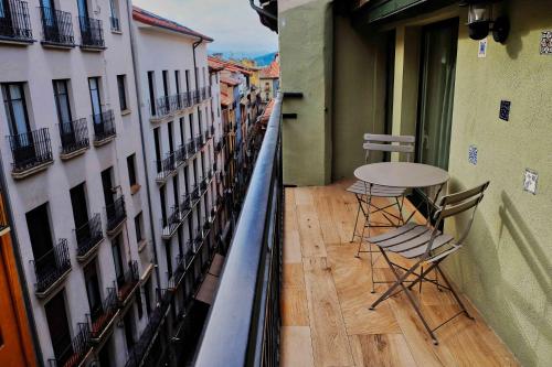 潘普洛纳Atico Estafeta的大楼内带桌椅的阳台
