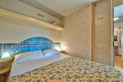 切齐纳码头Camping Village Mareblu的一间卧室配有一张蓝色床头板的床