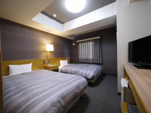 横手市横手因特路线酒店的酒店客房设有两张床和一台平面电视。