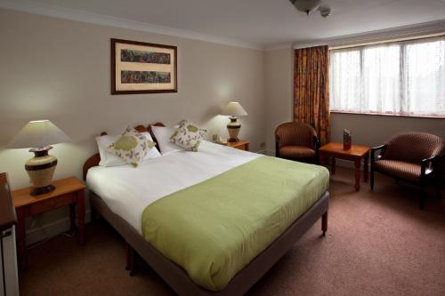 考文垂考文垂宫廷Spa酒店的酒店客房带一张大床和两张椅子