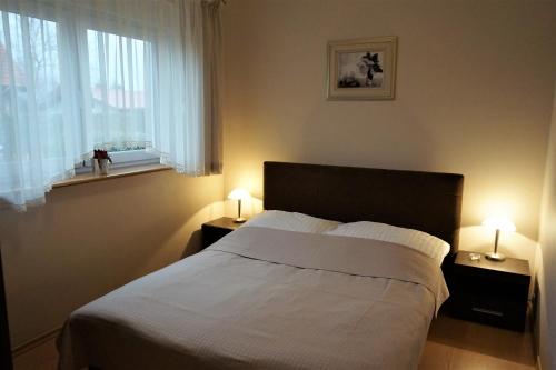 鲁斯诺沃Dom Bursztyn的一间卧室配有一张床和两张台灯。