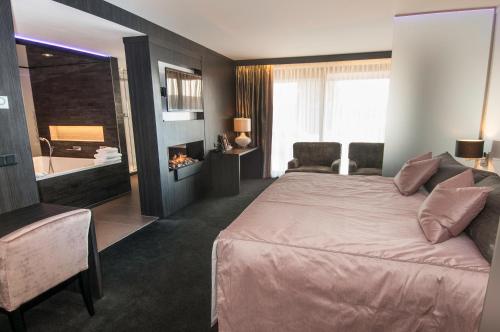 尼兰凡德尔瓦克内兰德 - 斯赫尔特吉恩波斯酒店的一间卧室设有一张大床和一个浴缸