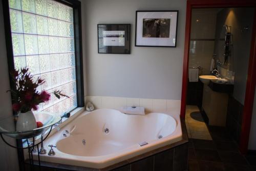 霍尔斯加普逃离天堂度假屋的带窗户的浴室设有大浴缸