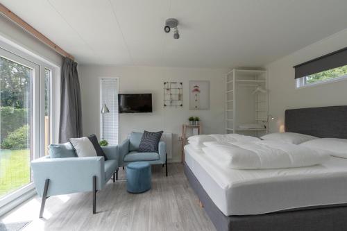 德科赫Chalet studio Mees - Texel的卧室配有一张白色大床和一把椅子