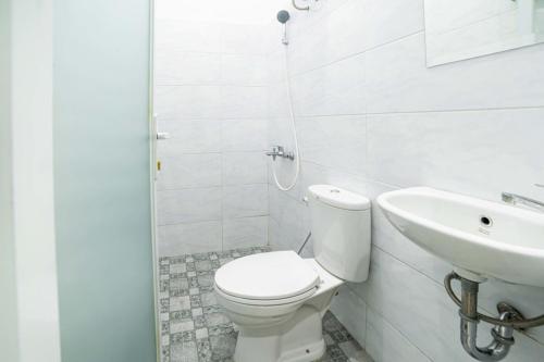 棉兰RedDoorz Plus near Thamrin Plaza Medan的白色的浴室设有卫生间和水槽。