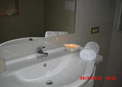 CarosinoBB La casa di Tella的白色浴室水槽、镜子和毛巾
