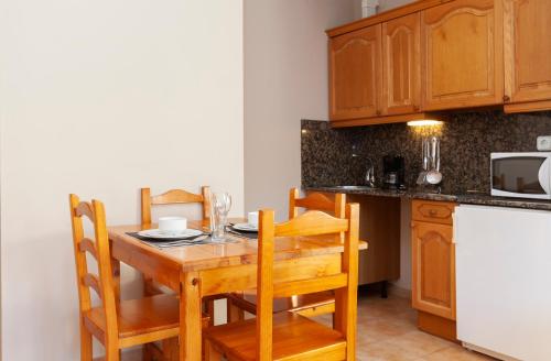 兰索尔Wuau! Apartamentos Solana de Ransol的厨房配有木桌、椅子和柜台