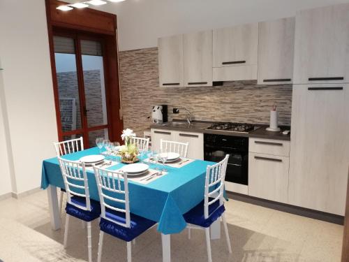 切萨雷奥港App.ti nel cuore di Porto Cesareo的厨房配有蓝色的桌子和椅子