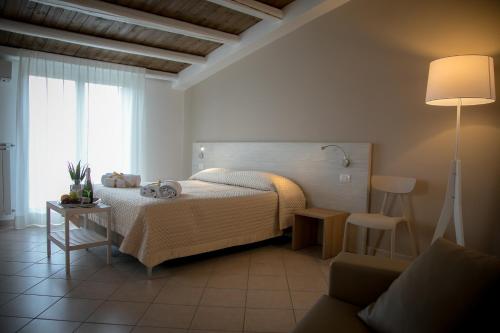 MussomeliMusmelia Rooms - Affittacamere的一间卧室配有床、灯和沙发