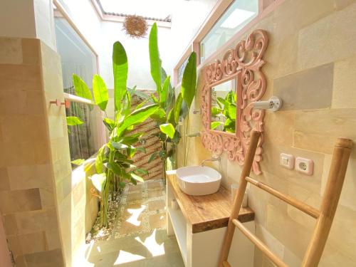 吉利特拉旺安Flamingo的浴室设有水槽、镜子和植物