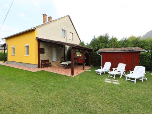 鲍洛通凯赖斯图尔Holiday Home Hibiscus by Interhome的黄色的房屋,配有白色的椅子和庭院