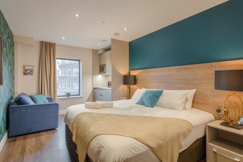 诺丁汉Dwell City Living的一间卧室设有一张大床和蓝色的墙壁