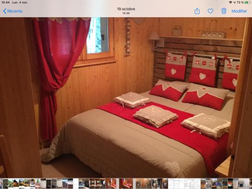 旺特龙Chalet le val’tin的一间卧室配有一张带红色和白色枕头的大床