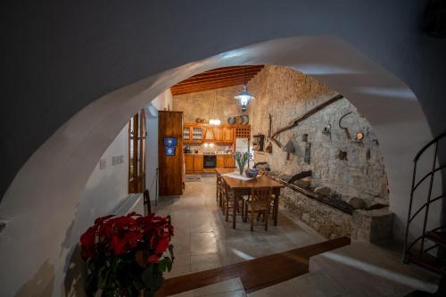洛弗Apanemia Inn House的一间厨房和带石墙的用餐室