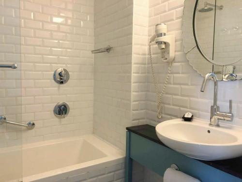 特拉维夫中心别致酒店 - 阿特拉斯精品酒店的一间带水槽、浴缸和镜子的浴室