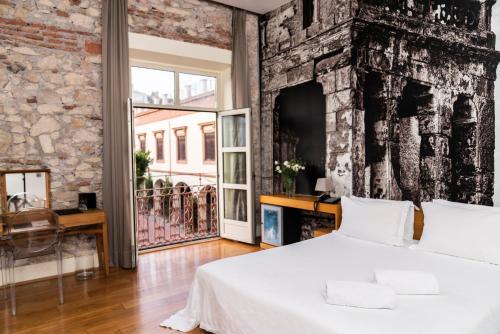 阿尔么丽亚艾尔酒店及老浴场的一间卧室设有砖墙和一张床