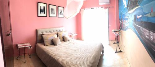 萨伊迪耶Appartement El Bahia Saidia destiné uniquement aux couple mariés, célibataires s'abstenir的卧室配有一张粉红色墙壁上的床铺