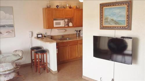 南帕诸岛La Internacional Condos O211的厨房配有壁挂式大屏幕平面电视