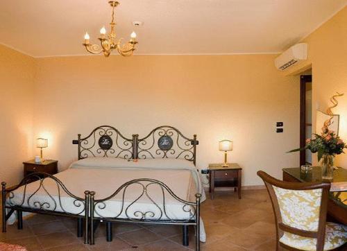 福扎格鲁奥古斯提尼亚纳酒店的一间卧室配有一张床、两把椅子和一个吊灯