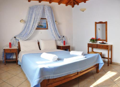 斯特尼瓦拉阿奥索斯Anatoli Villa的一间卧室配有一张带天蓬的蓝色床