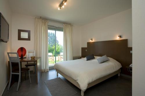 利尼翁河畔勒尚邦贝尔霍里赞酒店的一间卧室配有一张床、一张桌子和一个窗户。