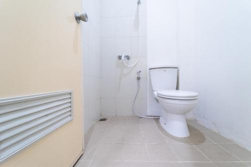雅加达KoolKost near Ragunan Zoo - Minimum Stay 6 Days的白色的浴室设有卫生间和淋浴。