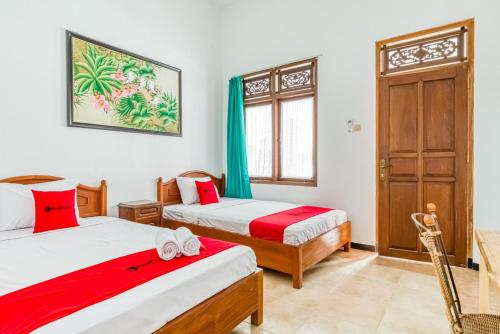玛琅RedDoorz Syariah near Gor Ken Arok的一间卧室设有两张床和窗户。