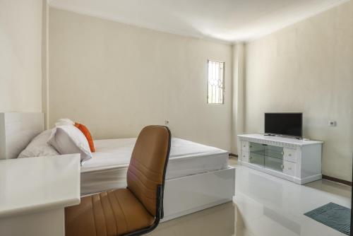 泗水KoolKost Syariah near Kaza Mall Surabaya的一间卧室配有一张床和一张书桌及电视
