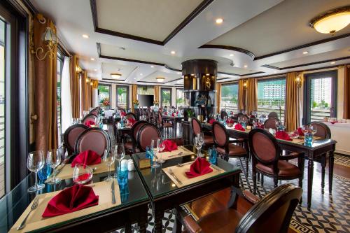 下龙湾Athena Royal Cruise的餐厅配有桌椅和红色餐巾