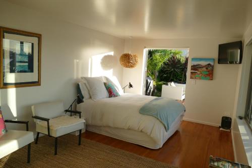 纳尔逊Waterfront Bliss的卧室配有床、椅子和窗户。
