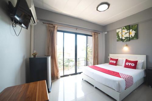 大城OYO 465 Krung Kao Traveller Lodge的一间卧室设有一张床和一个大窗户