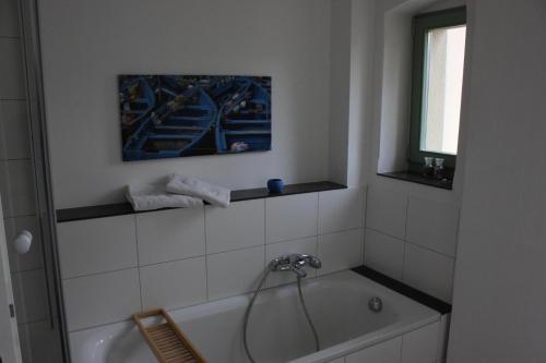 德累斯顿Traumhafte Etagenwohnung in Günderzeitvilla的带浴缸的浴室和窗户。