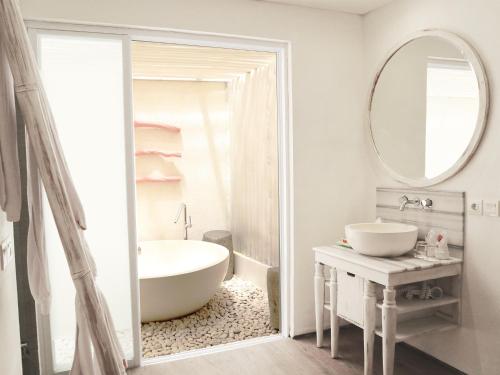库塔落日余晖大道哈里斯度假酒店的带浴缸、水槽和镜子的浴室