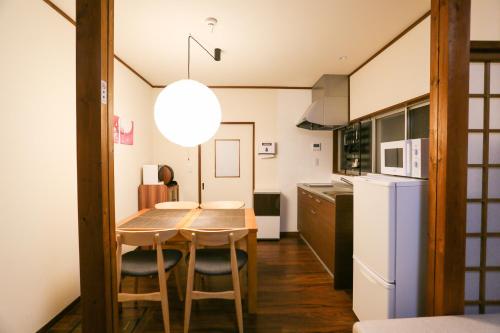 高山Private House HidaTakayama的厨房配有桌椅和冰箱。