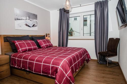 平茨高谷地霍勒尔斯巴赫Kitz Juwel Top 4的一间卧室设有红色的床和窗户。