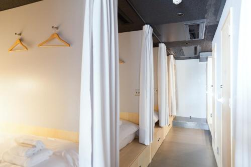 福山Area Inn Fushimicho Fukuyama Castle Side 2-8的卧室配有白色窗帘和床