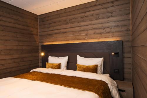 朗伊尔城Svalbard Hotell | Lodge的一间卧室配有一张带木墙的大床