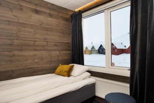 朗伊尔城Svalbard Hotell | Lodge的小房间前方设有窗户和长凳
