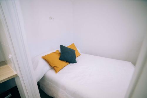 普拉加德阿罗Old Side Platja d'Aro的一张白色的床,上面有两个枕头