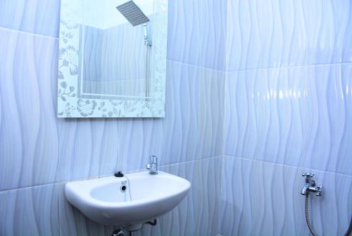 比哈尔Sapu Nyapah Losmen Syariah Tanjung Setia的白色的浴室设有水槽和镜子