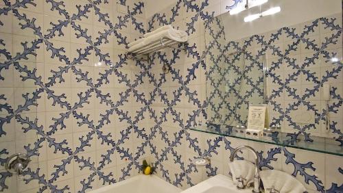 索伦托亚敏塔大酒店的浴室拥有蓝色和白色的瓷砖墙