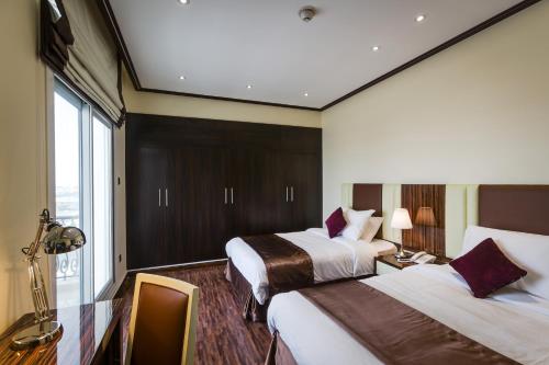 迪拜The View Al Barsha Hotel Apartments的酒店客房设有两张床和窗户。