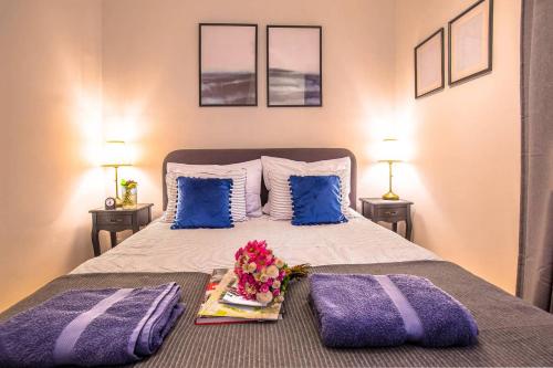 萨格勒布Number 28 Boutique Apartment的一间卧室配有一张带紫色枕头的床和一盘鲜花