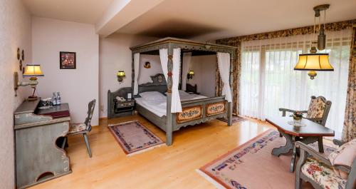哈茨山区黑尔茨贝格海泽尔酒店的一间卧室设有一张天蓬床和木地板。