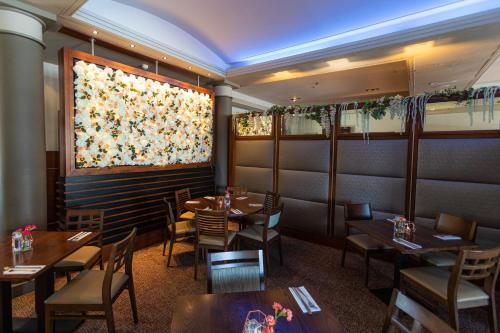 斯特灵Fletcher's Restaurant Bar & Rooms的餐厅设有桌椅和窗户。