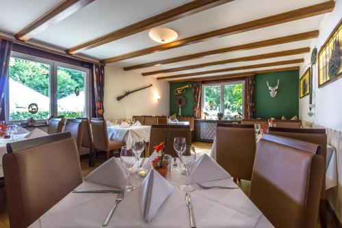 斯图加特库灵纳瑞姆格勒慕斯酒店的餐厅设有白色的桌椅和窗户。