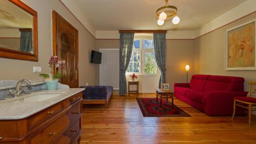 布拉伊埃斯布拉伊埃斯湖泊酒店的一间带红色沙发的浴室和一间客厅